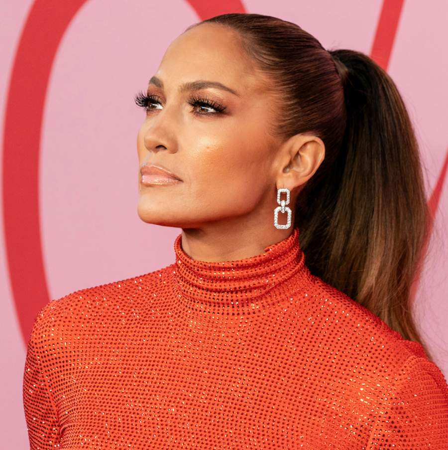 Jennifer Lopez with a tight ponytail, square silver earrings and a red sparkling top